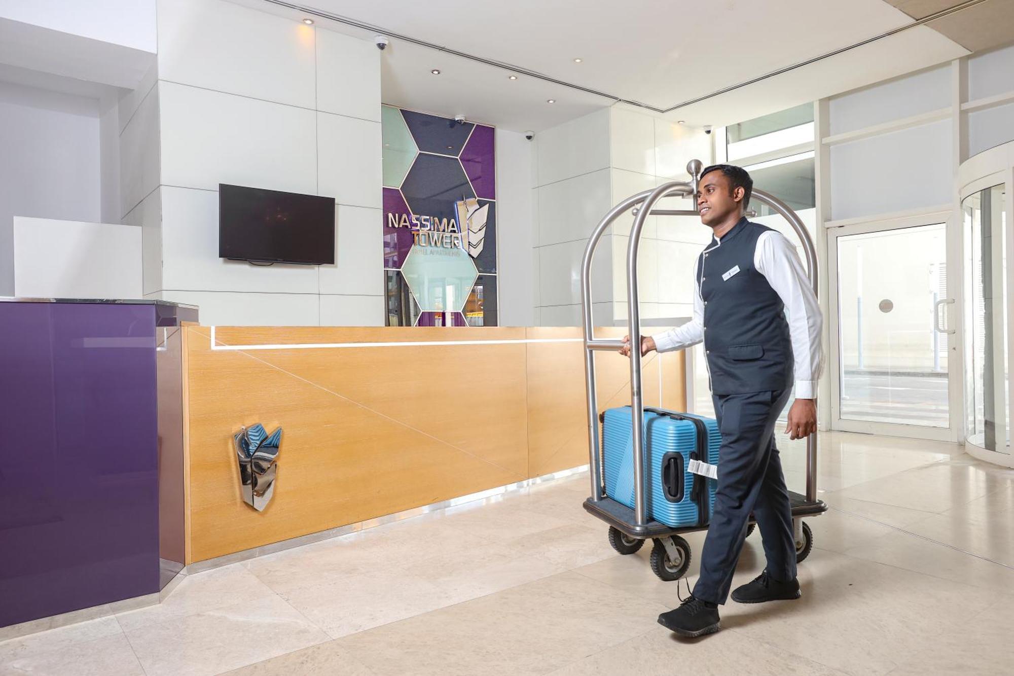 ナシマ タワー ホテル アパートメント ドバイ エクステリア 写真 A bellboy pushing a luggage cart